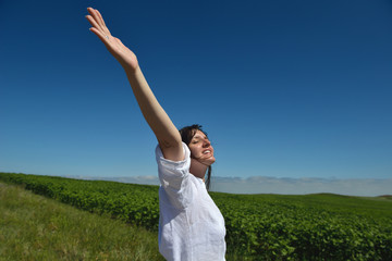 Young happy woman in green field
