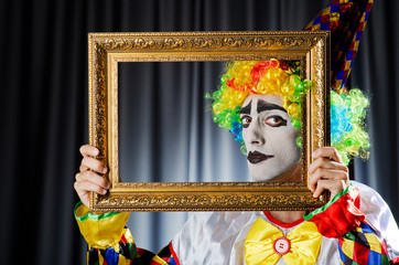 Clown with picture frames in studio
