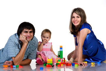 father, mother and baby playing together and building of blocks