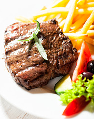 Grilled beef steak with french fries and salad