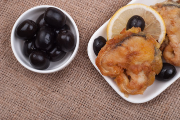 Fried fish with a lemon and olives
