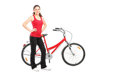 Fototapeta na wymiar Full length portrait of a sporty girl posing next to a bike