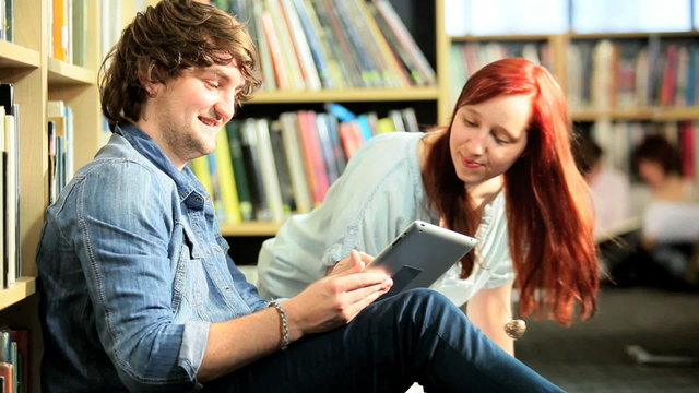 Couple networking online on tablet in university 
