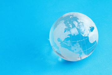 A glass globe on light blue