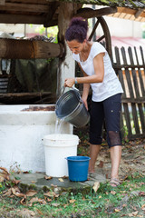 Woman getting water from well