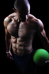 Fototapeta na wymiar Muscular athlete man exercise on a black background