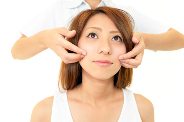 Fototapeta premium エステでフェイスマッサージを受けている女性