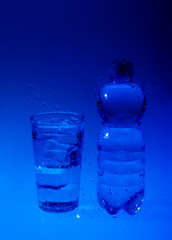 Water drops background with unfocus bottle and glass of water
