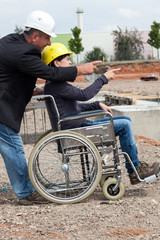 Architect shows disabled woman in wheelchair construction sites