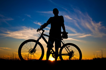 Obraz na płótnie Canvas cyclist with a bike silhouette on a sunset sky