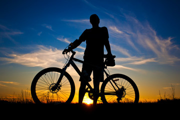 Obraz premium cyclist with a bike silhouette on a sunset sky