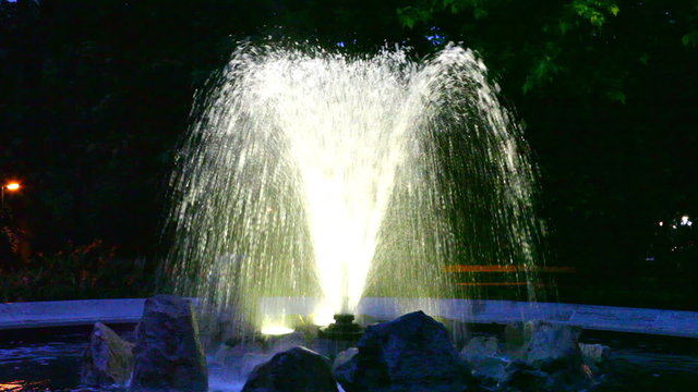 Small fountain with illumination in twilight