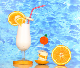 Delicious milk shake with fruit on table on blue sea background