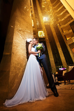 happy bride and groom in the modern hotel hall