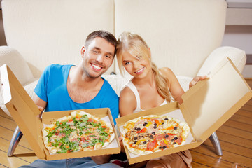 romantic couple eating pizza at home