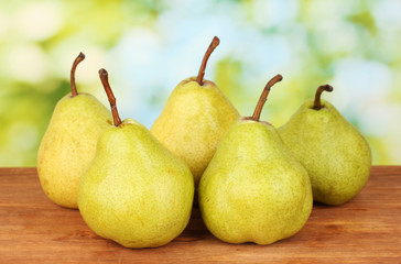 Ripe pears on colorful green background