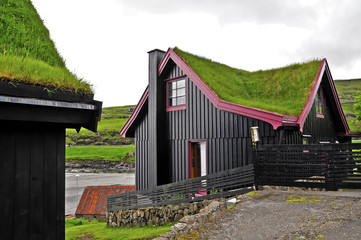 Fototapeta na wymiar Grass-pokryte domy na Wyspach Owczych w miejscowości Leynar