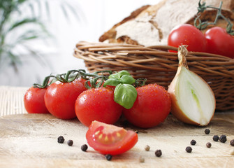 Tomaten, Zwiebel und ein Brotkorb mit Brot