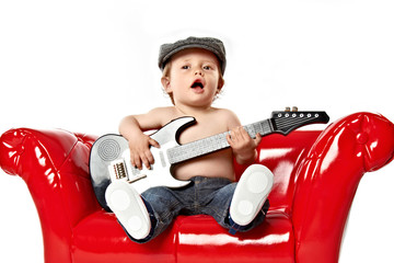 kleiner junge singt und spielt gitarre