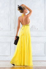 Beautiful blonde woman in a long yellow dress.