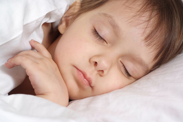 Fototapeta na wymiar Small girl lying on bed at home