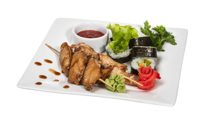 Buffalo chicken wings on plate with sushi