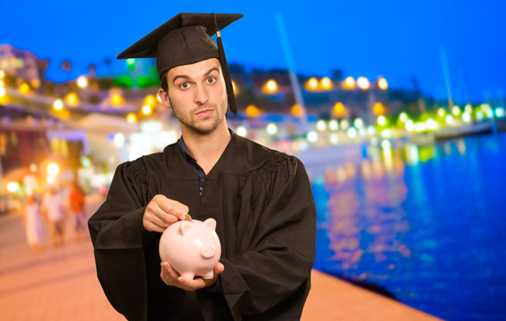 Graduate Man Holding Piggybank