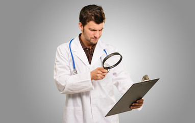 Doctor With Magnifying Glass And Clipboard