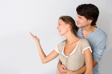 Young couple on white background designating message