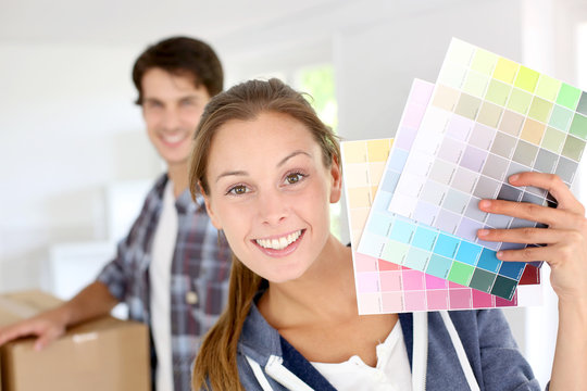 Smiling girl holding colour charts to decorate house