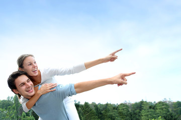 Man giving piggyback ride to girlfriend outside