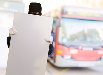 Portrait of a man wearing mask holding blank card