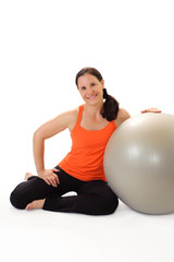 Fototapeta na wymiar Woman in her 40s wearing workout clothing with an exercise ball.