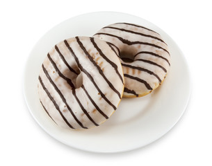 Two donuts with icing on a white plate isolated on white