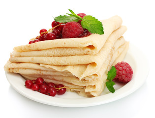 Delicious pancakes with berries and jam on plate on wooden