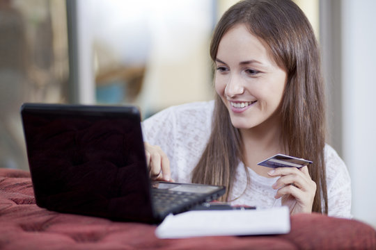 Happy young woman shopping online