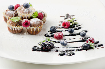 Cupcakes with fresh berries  and sweet  christmas tree