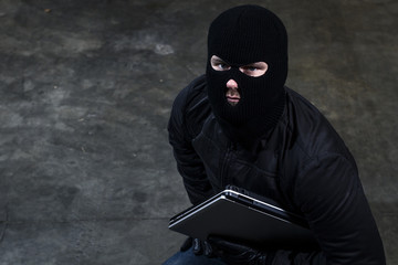 hacker holding a computer