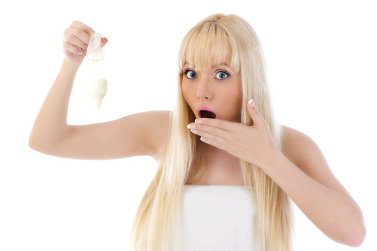 Surprised woman holding condom on white background