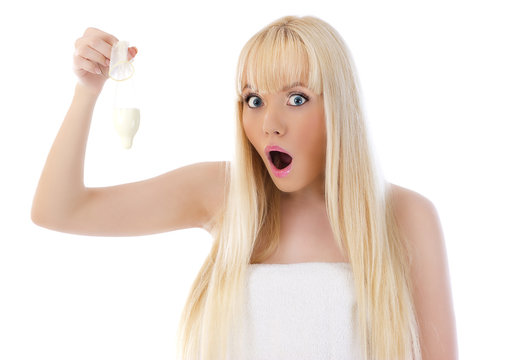 Surprised young woman holding condom