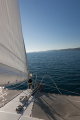 Fototapeta na wymiar Yacht on the open ocean. Island on the horizon.