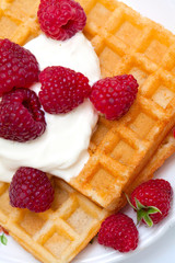 waffles with wheaped cream and raspberrries