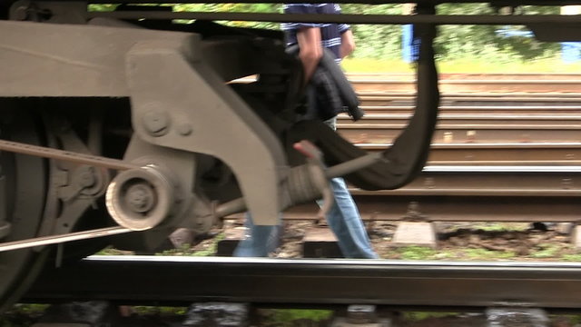 Feet of the person going behind a railway car