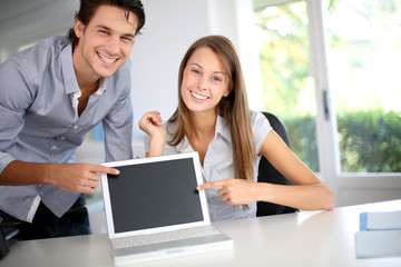 Successful business team showing laptop screen