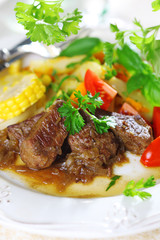Beef stew with vegetables and salad of fresh tomato.