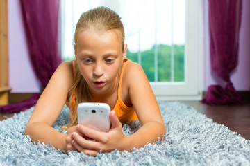 Familie - Kind spielt mit Handy oder Smartphone