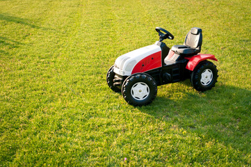 Fototapeta na wymiar Tractor toy isolated over grass.