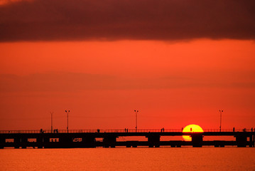 Fototapeta na wymiar The pier on the backdrop of the setting sun