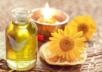 Obraz na płótnie Canvas Essential oils for aromatherapy and yellow flowers