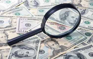 Magnifying glass lying on banknotes